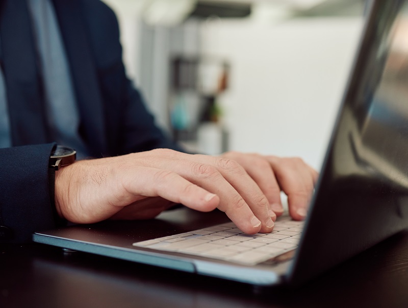 a person typing on a laptop.