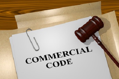 a gavel and a paper with text on it. Containing the words: commercial code