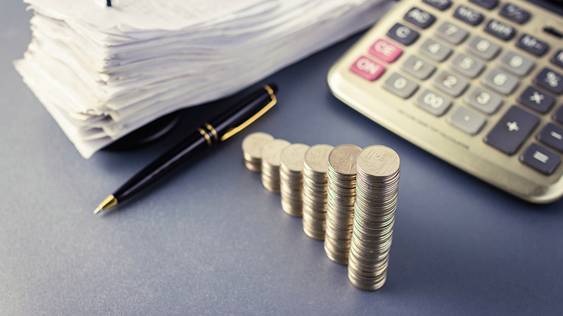 stacks of coins next to a calculator.