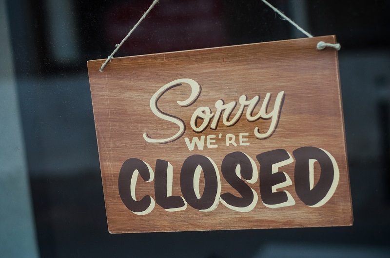 Horizontal Close Up Shot Of Store Closing Sign On Business