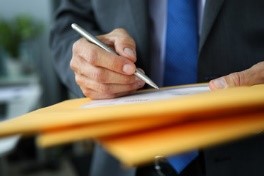 a close-up of a person writing on a document.