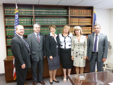 a group of people standing in front of a bookcase.