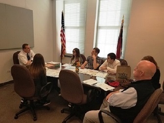 a group of people sitting around a table.