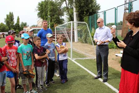 a group of people standing around a person holding a baseball.