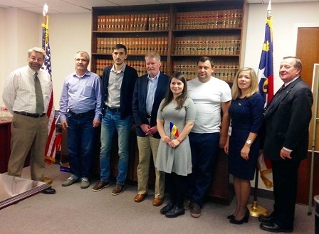 a group of people standing in front of a bookcase.