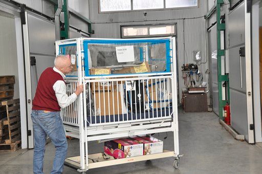 a person pushing a baby crib.