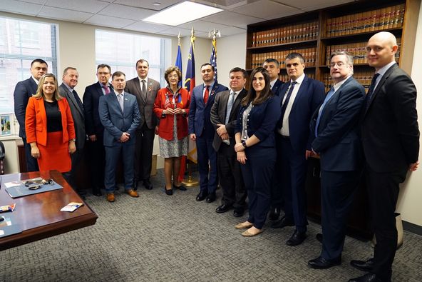 a group of people standing in a room.