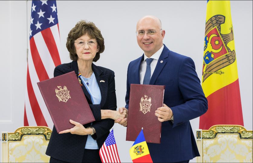 a person and person holding books in front of flags.